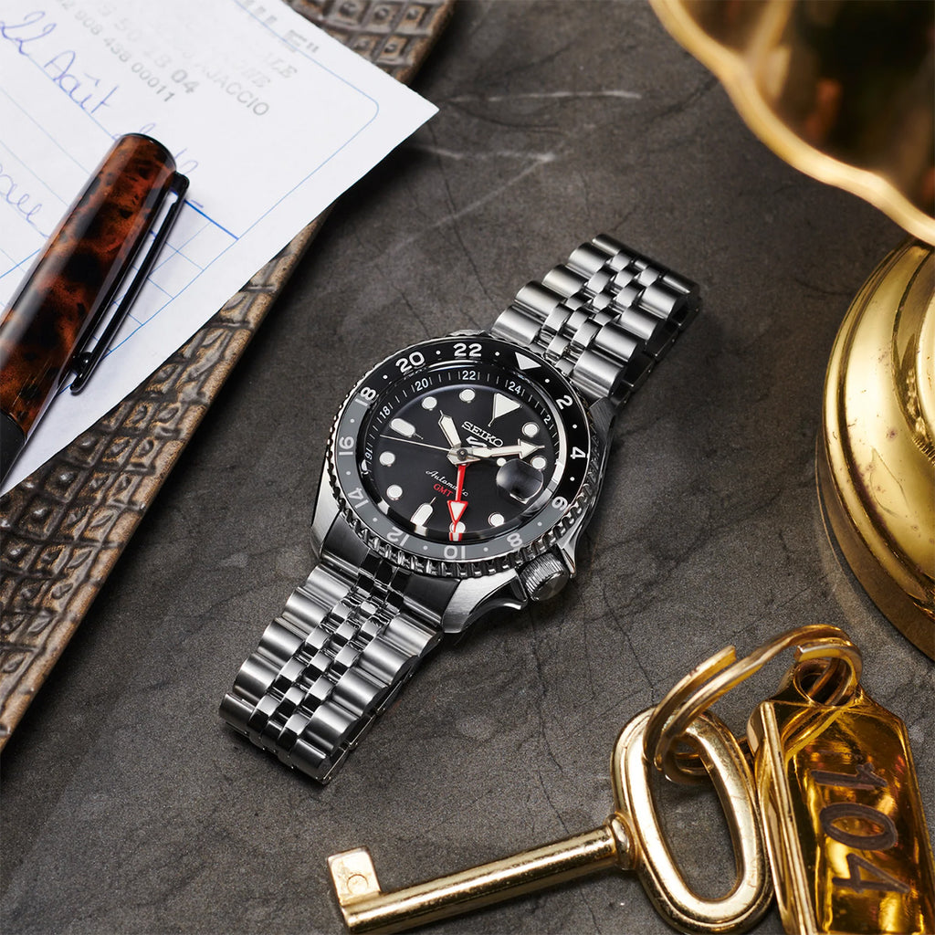 Seiko 5 Sports GMT SSK001 black dial watch lying among stationery and keys